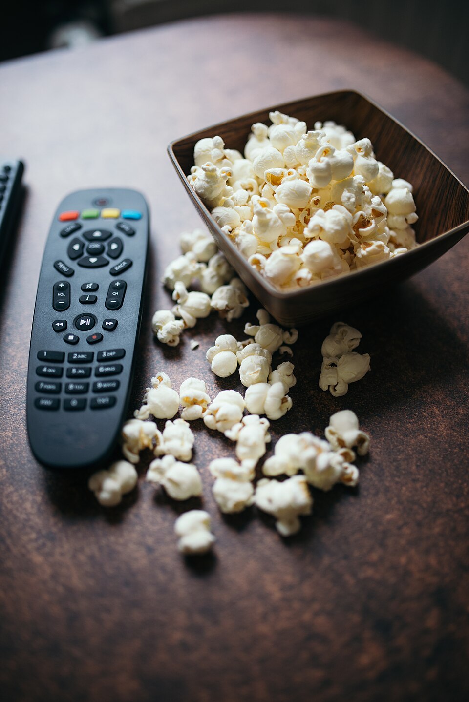 Fjärrkontroll i handen framför tv, redo att välja iptv bolaget