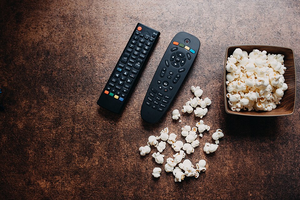 Fjärrkontroll och popcorn framför tv redo att jämföra iptv leverantörer