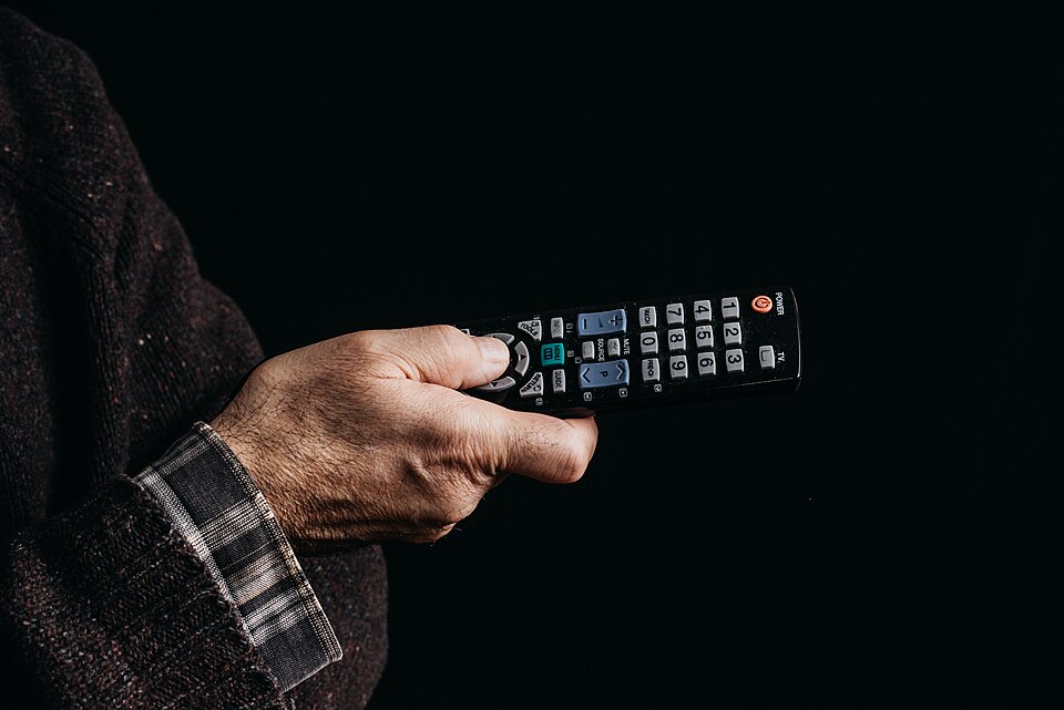 Person använder fjärrkontroll för att styra smart iptv pro på tv